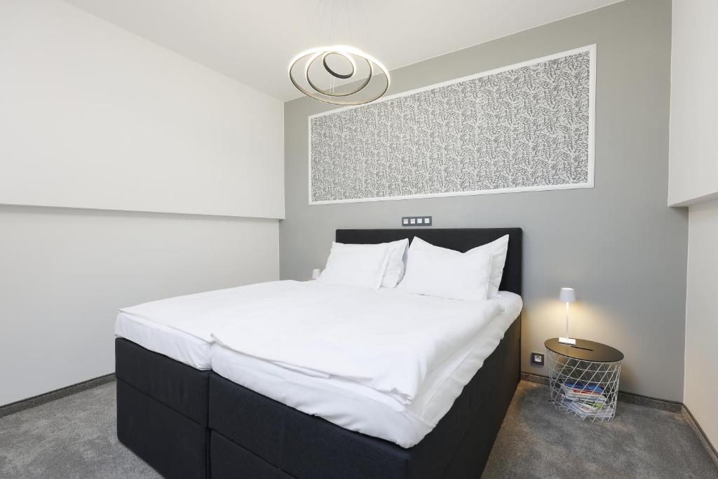 una camera da letto con un grande letto con lenzuola bianche di Plavírna a Otovice