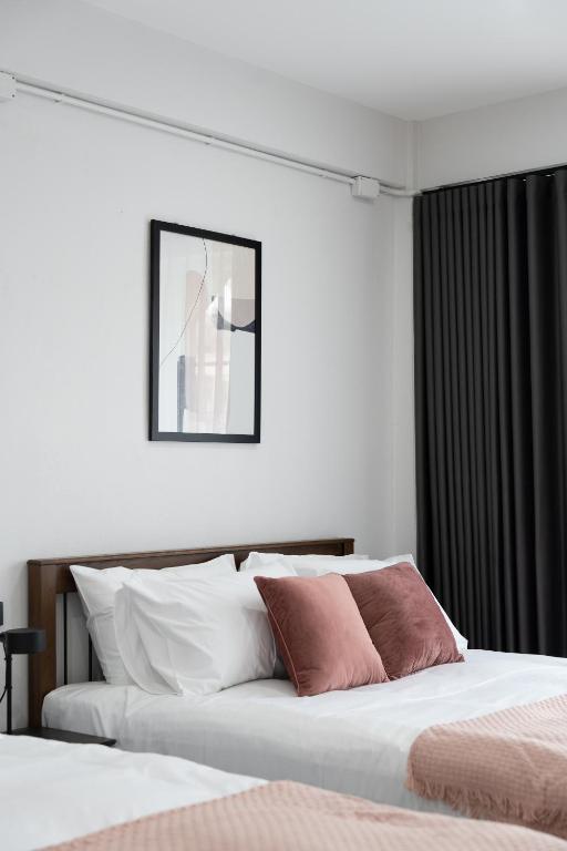a bedroom with two beds and a picture on the wall at Knox Hatyai just 10 steps to Greenway Night Market in Sathani Khlong Rian
