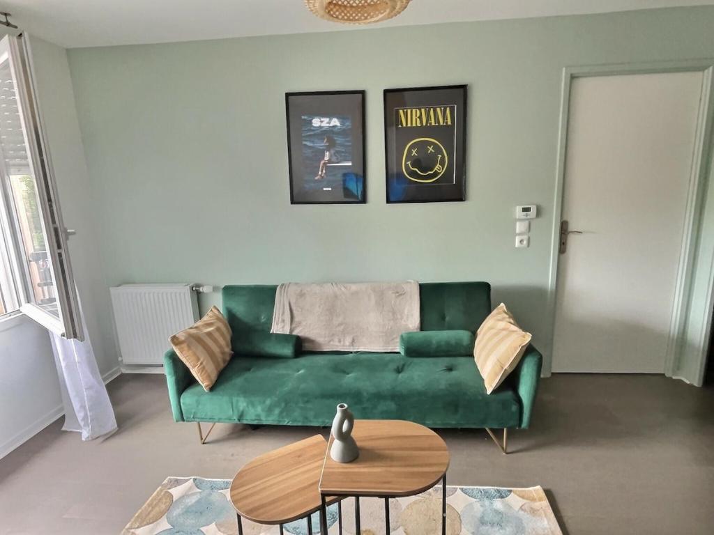 un salon avec un canapé vert et une table dans l'établissement Confort Exotique Idéal Pour Les Familles Et Les Groupes, à Persan