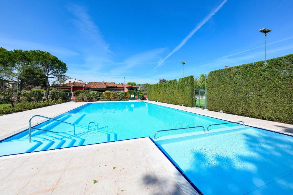 a large swimming pool with blue water at Acquarius Resort Sirmione - MGH in Sirmione