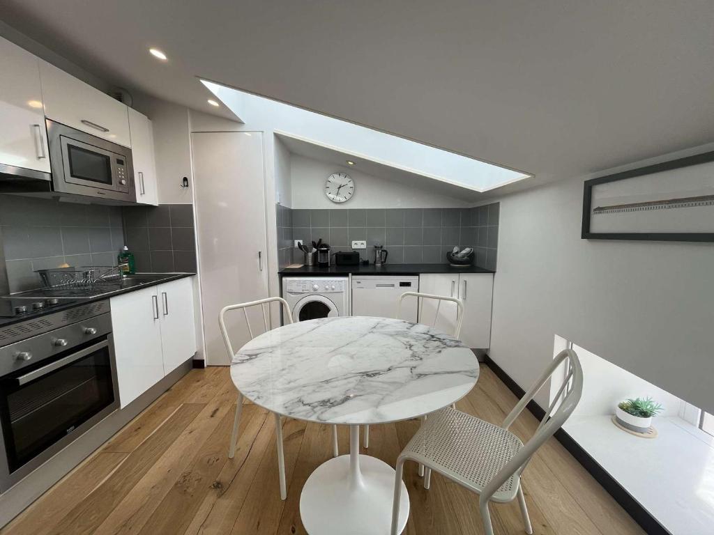 une cuisine avec une table et des chaises dans une pièce dans l'établissement Charmant T2 climatisé dans monument historique à Rochefort, proche centre-ville - FR-1-246B-14, à Rochefort