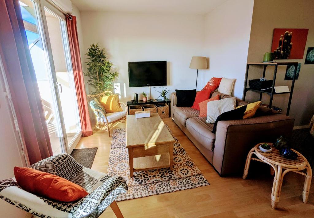 un salon avec un canapé et une table dans l'établissement Refuge du pilote tout équipé au calme avec balcon, à Dax