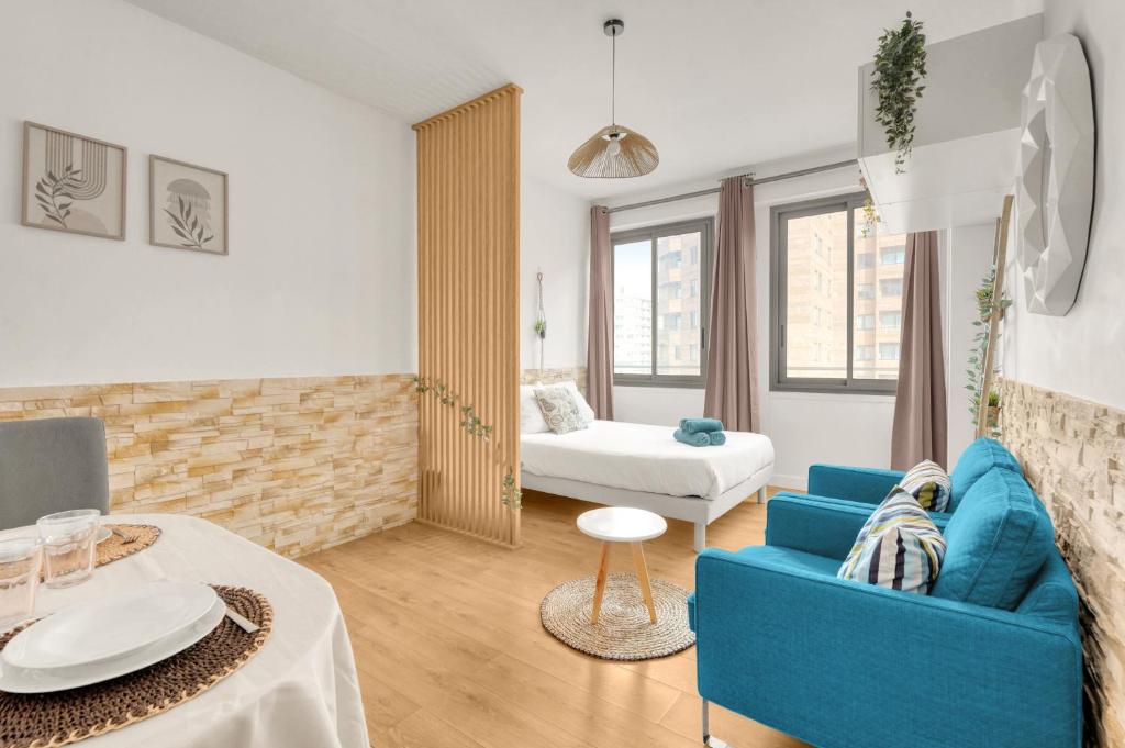 un salon avec un canapé bleu et une table dans l'établissement Le Bohème Chic - Studio Cosy - Métro & Gare, à Toulouse
