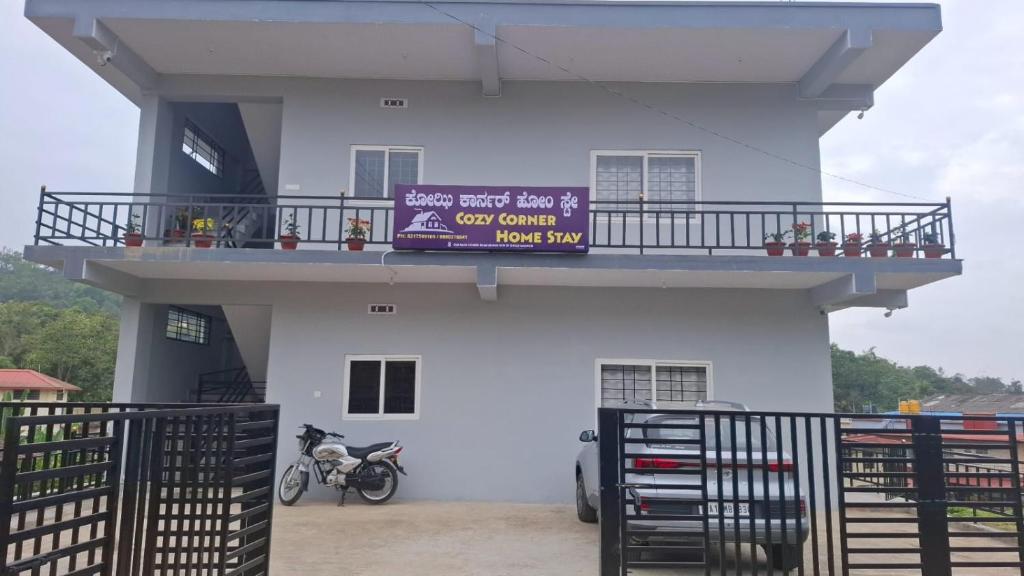 a white building with a sign on top of it at Cozy Corner Homestay in Madikeri