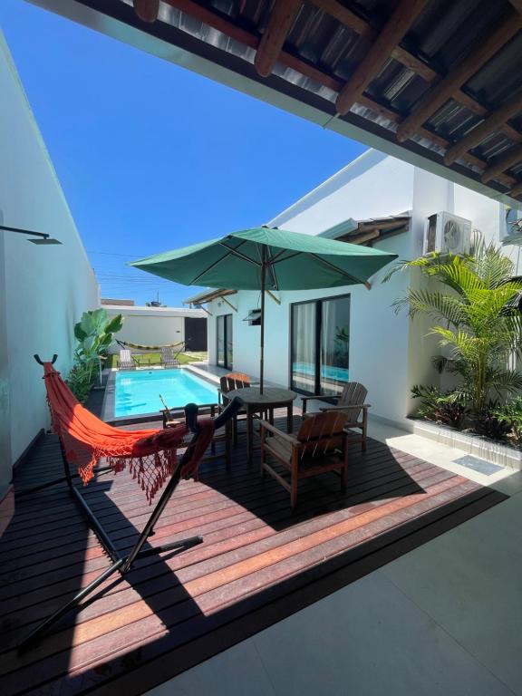 a hammock on a deck next to a swimming pool at Hospedaria Casa Branca in Porto Seguro