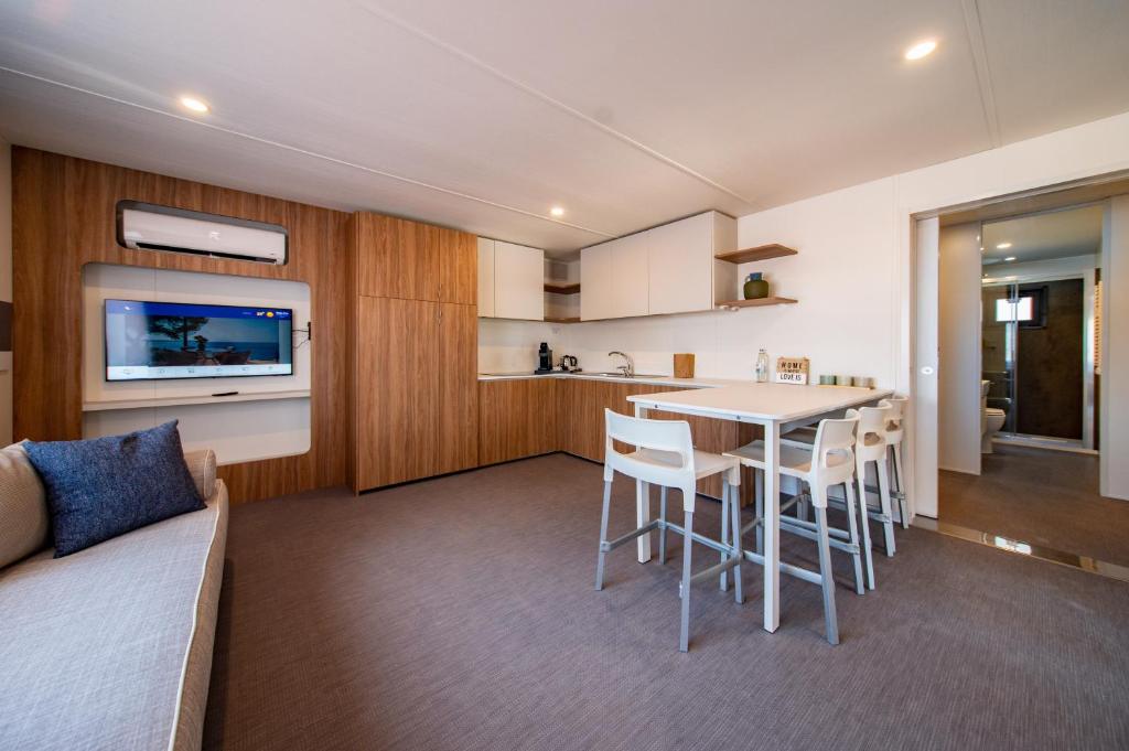 a kitchen and living room with a table and chairs at Arena Stoja Camping Homes in Pula
