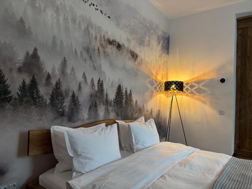a bedroom with a painting of trees on the wall at Zen Retreat Apartment in Sinaia
