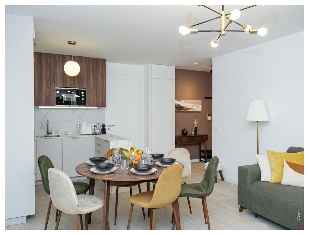 une salle à manger et un salon avec une table et des chaises dans l'établissement Chic appart 3 pièces avec Parking et Terrasse à 35min de Paris, à Romainville