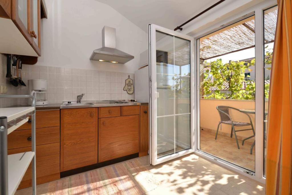 a kitchen with a sliding glass door leading to a patio at Apartment Pia Murter in Murter