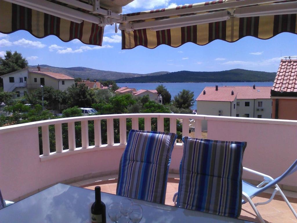 ein Tisch und Stühle auf einem Balkon mit Blick auf das Wasser in der Unterkunft Apartments Marijana Zaboric in Zaboric