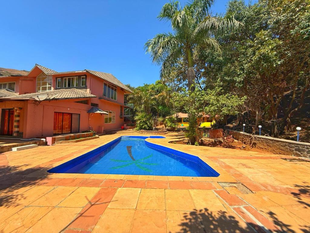 a swimming pool in the yard of a house at Captans Stay in Lonavala