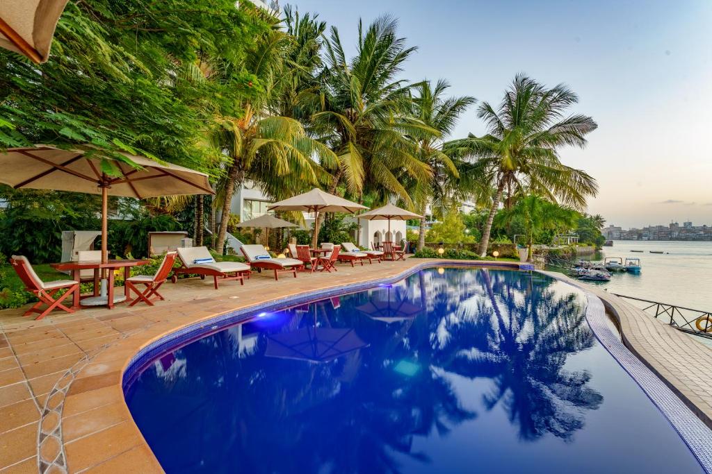 a pool at a resort with chairs and umbrellas at Waterfront Residences in Mombasa