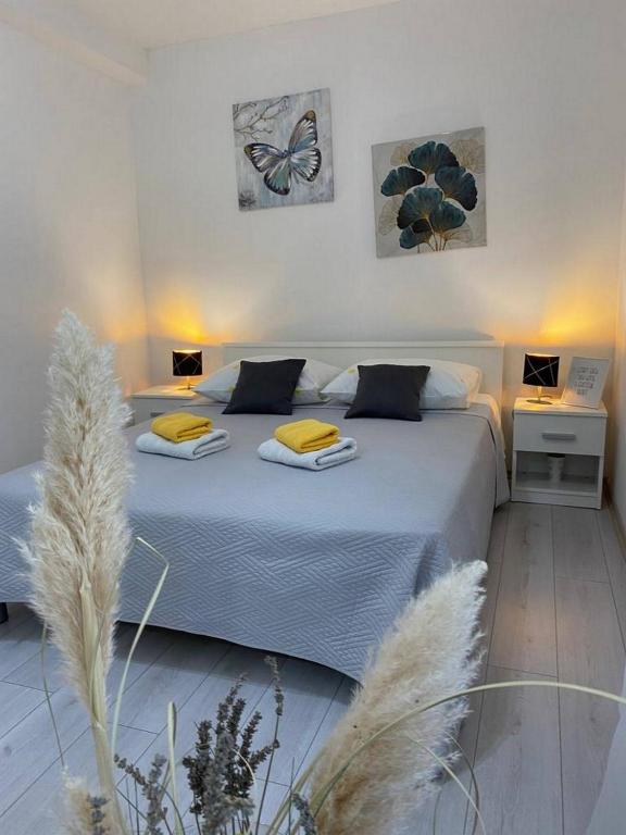 a bedroom with a bed with blue sheets and a butterfly on the wall at Rural Apartment Ante in Drniš