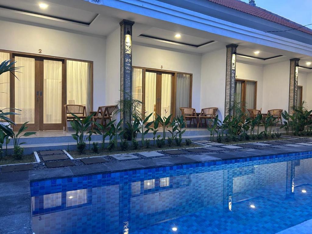a swimming pool in front of a house at Alit Guest House in Uluwatu