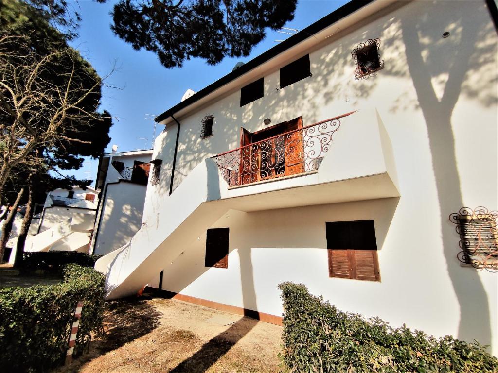 a white building with a staircase and a balcony at RESIDENCE El Patio C-4 in Rosolina Mare
