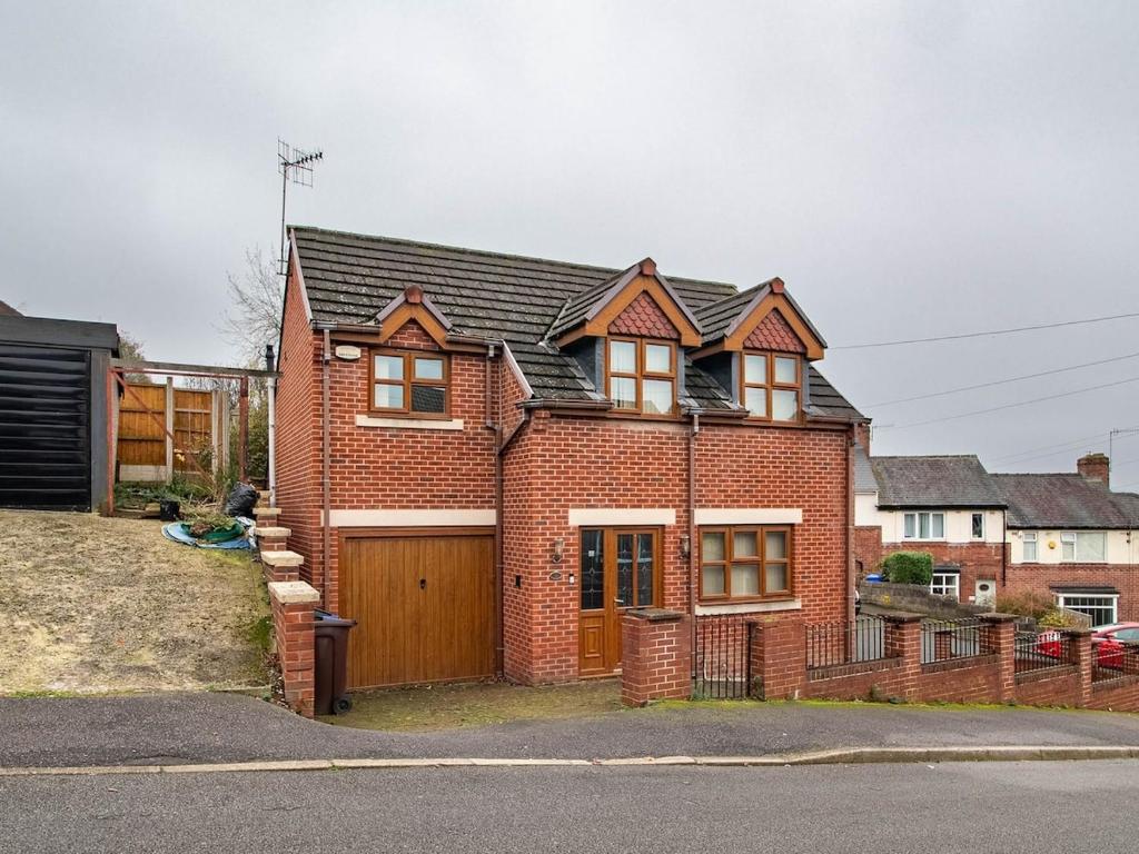 a red brick house with a wooden garage at Exclusive 3-Bedroom Villa in Sheffield in Sheffield
