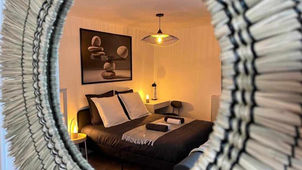 een slaapkamer met een bed en een spiegel bij Le Roi du Lac - Disneyland Paris in Lognes