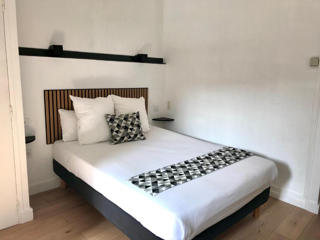 Postel nebo postele na pokoji v ubytování Hôtel Croix Baragnon