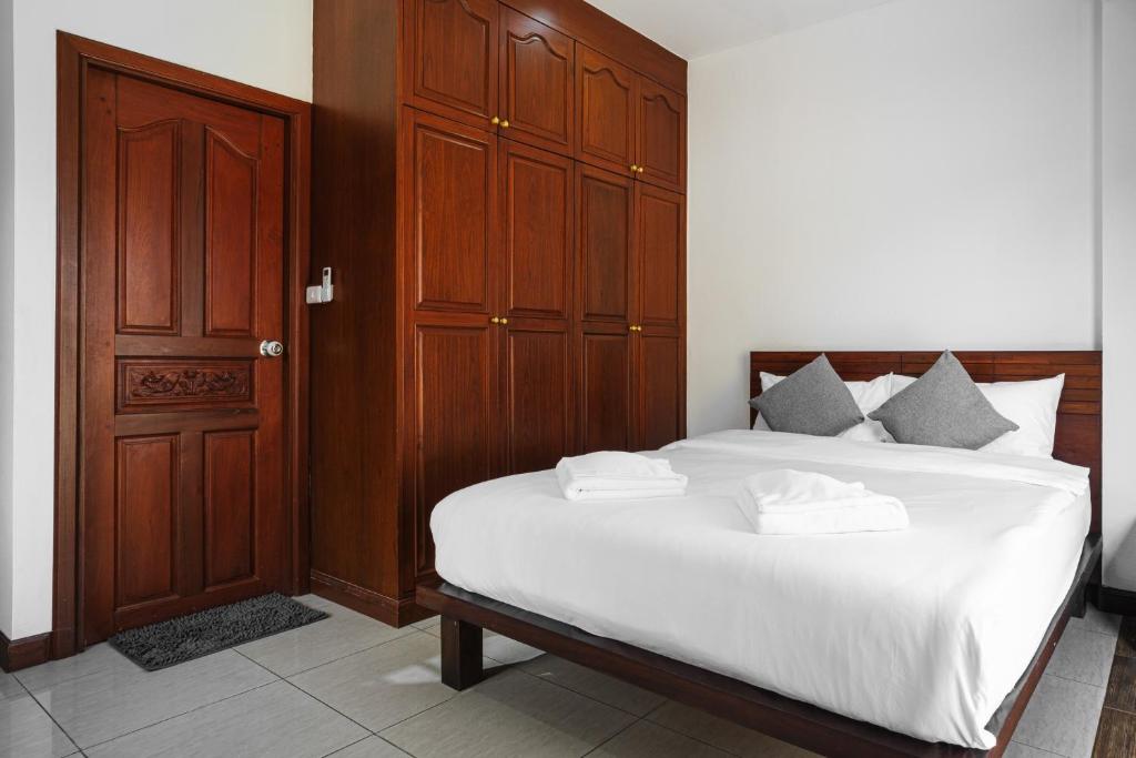 a bedroom with a large bed with white sheets and pillows at Luxury Massarossa Pool Villa Pattaya-21 in Pattaya Central