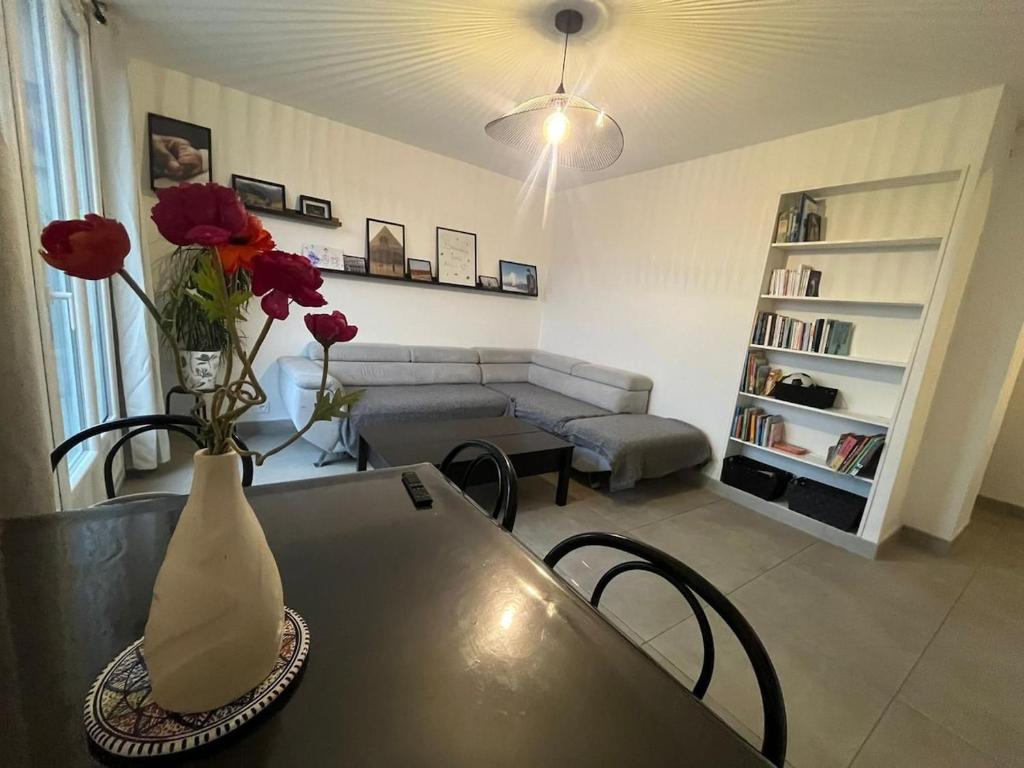 - un salon avec une table et un vase avec des fleurs dans l'établissement L'Alpin, 2 chambres, Parking, Vue montagne, à Grenoble