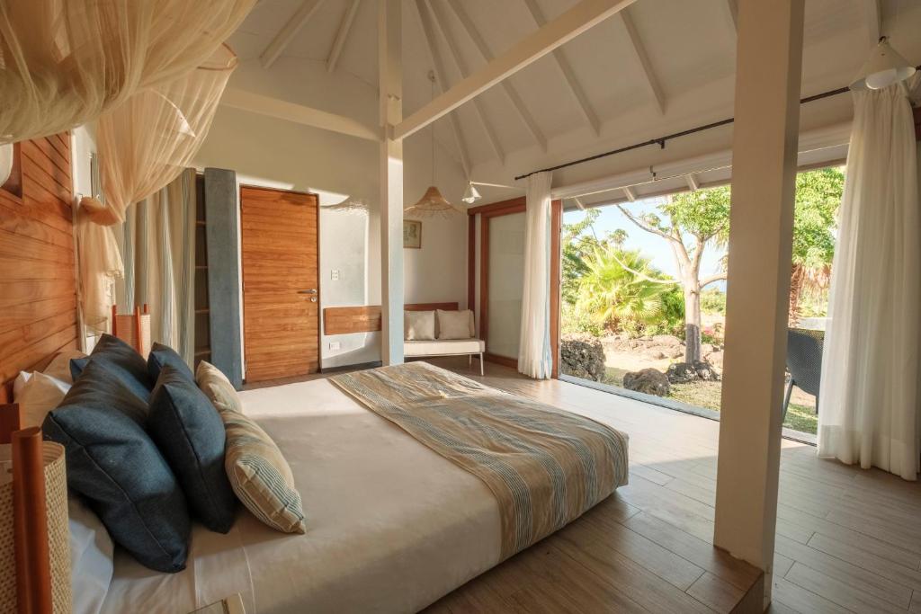 Un dormitorio con una cama grande y una ventana grande. en Altiplanico Rapa Nui, en Hanga Roa