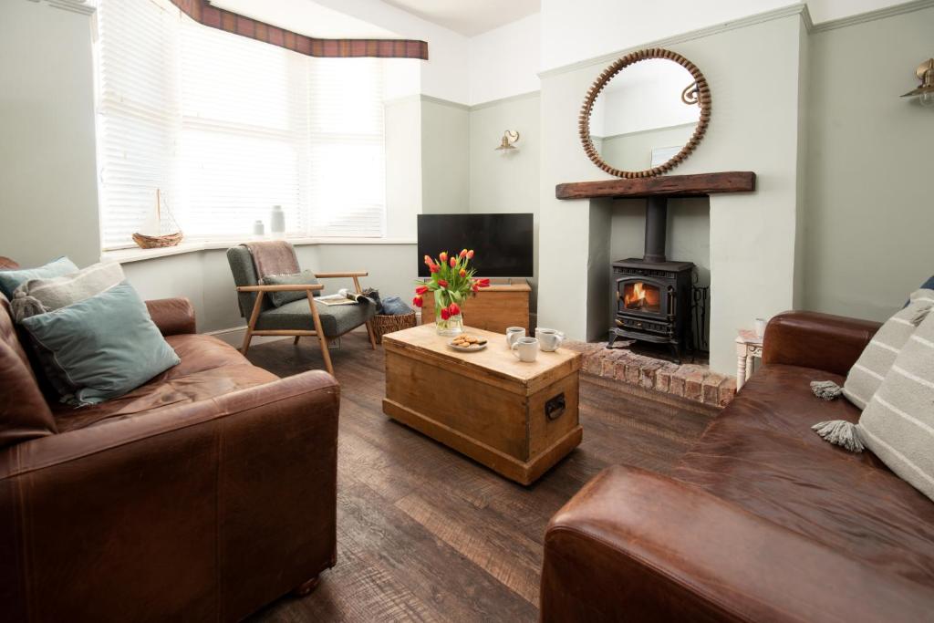 a living room with a couch and a fireplace at Driftwood Cottage by Coast & Country Stays in Seahouses