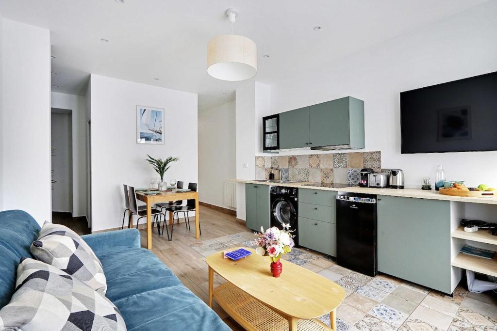 un salon avec un canapé bleu et une cuisine dans l'établissement Wonderful 6P apartment - Amiral, à Paris