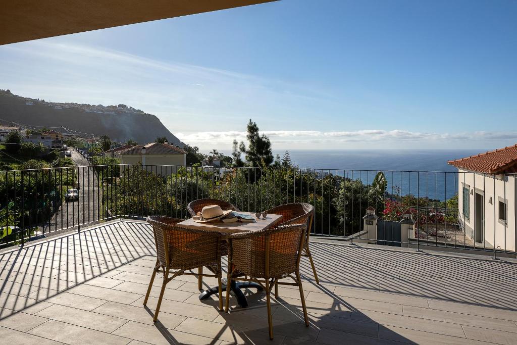 a patio with a table and chairs on a balcony at Marco 4 Seasons- Spring in Arco da Calheta