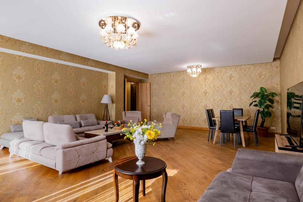 Una sala de estar con sofás y una mesa con flores. en Luxury accommodation, en Tiflis
