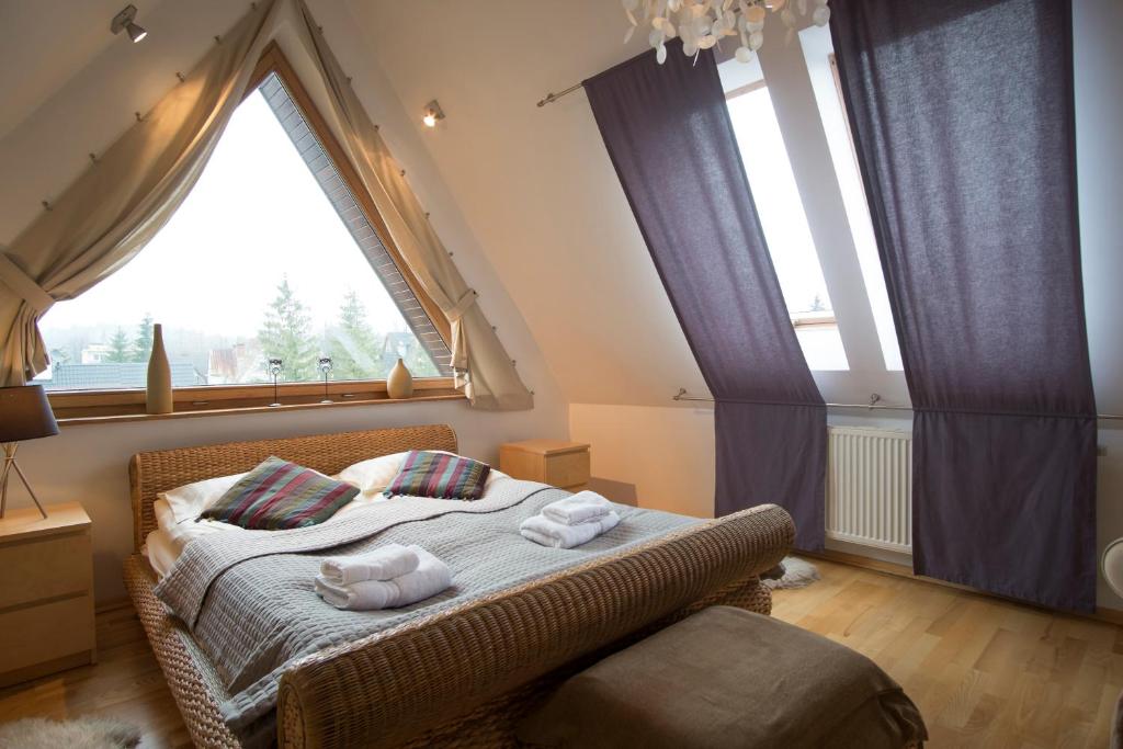 um quarto com uma cama e uma grande janela em Apartament Z Widokiem Na Giewont APARTZAKOP em Zakopane
