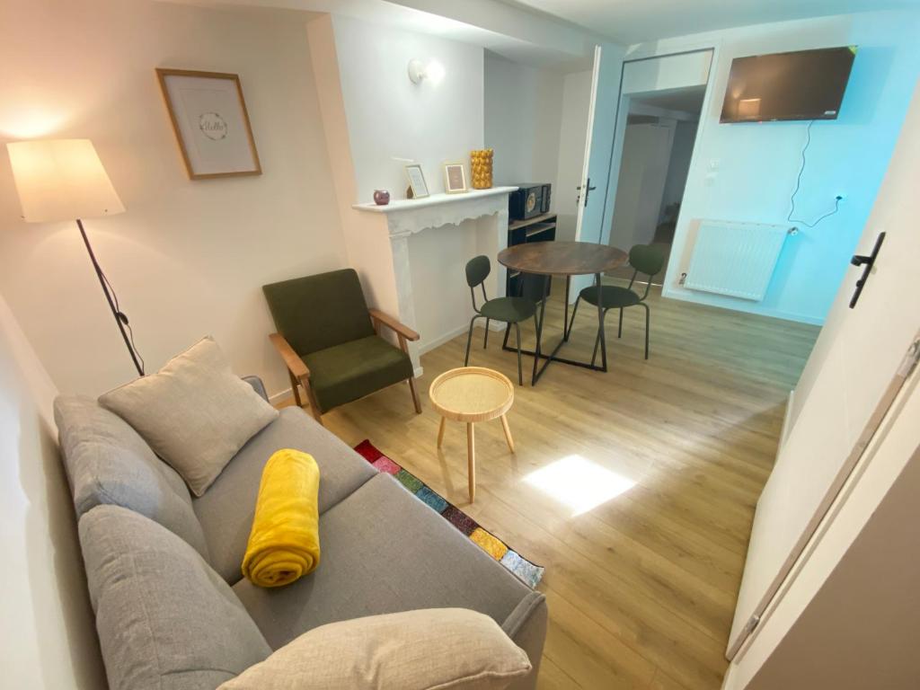 un salon avec un canapé et une table avec des chaises dans l'établissement Souplex Laverie Jardin Parking Villa Margareth, à Dunkerque