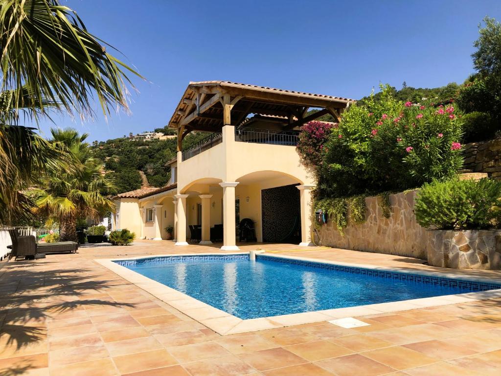 une villa avec piscine devant une maison dans l'établissement Villa Joya climatisée pour 8 personnes avec piscine et vue mer à La Londe-Les-Maures, à La Londe-les-Maures
