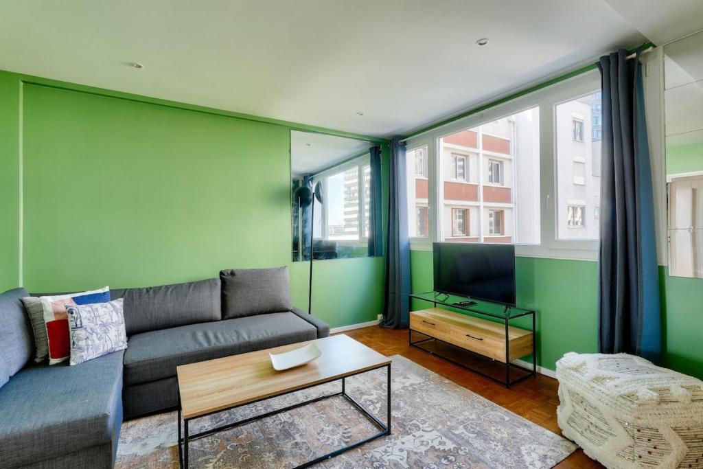 - un salon avec des murs verts et un canapé dans l'établissement Stunning 1BR flat 10 min from the Eiffel Tower, à Paris