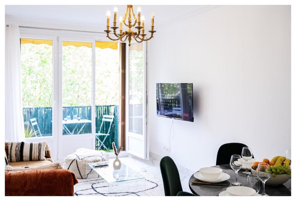 - un salon avec une table à manger et un lustre dans l'établissement Joli 3 pièces à 100m du métro, proche de Paris, à Pantin