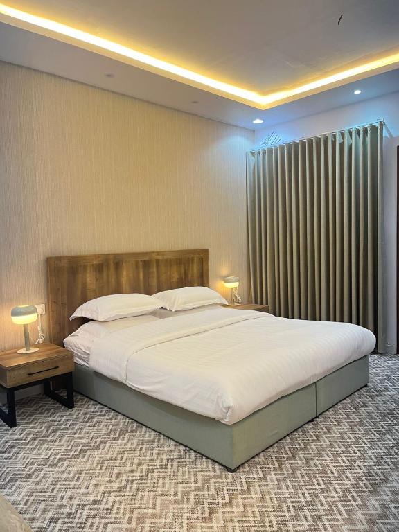 a bedroom with a large bed and a large window at Al-Jamwaut B in Medina
