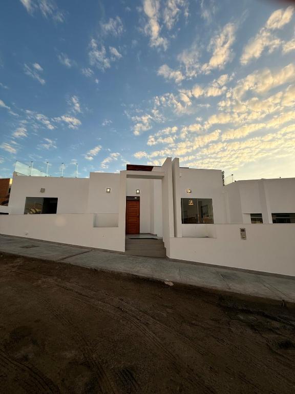 a large white building with a sky at Beach house Sol Mar y Relax in Cerro Azul