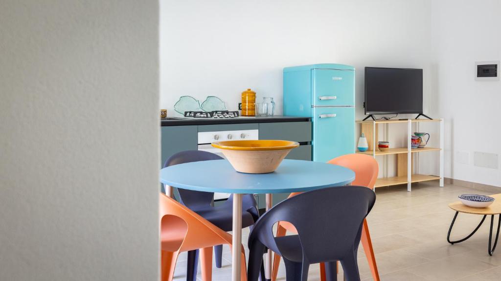 a kitchen with a blue table and chairs at Casa BON BON in Triscina