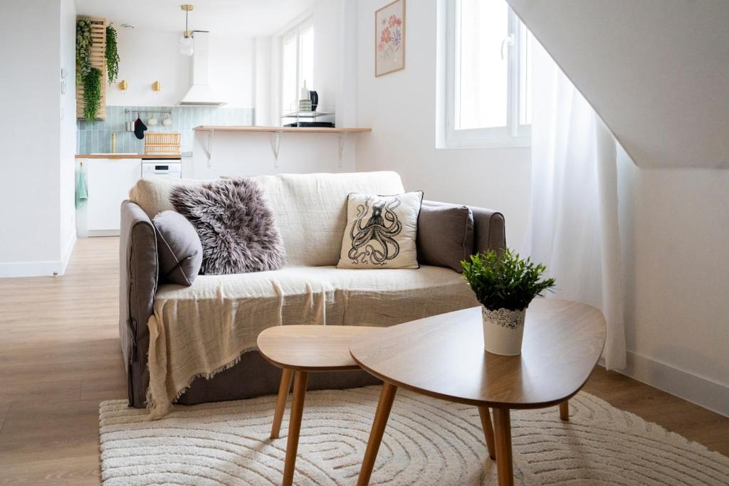 un salon avec un canapé et une table dans l'établissement Appartement sur les quais, à Caen