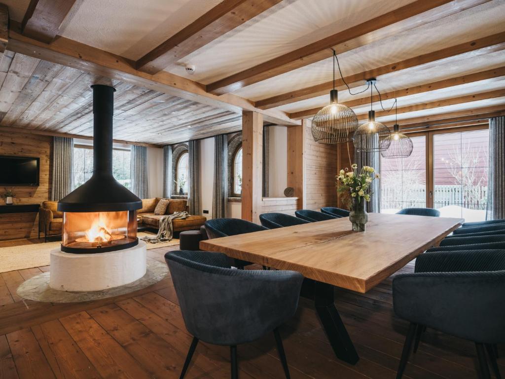 a living room with a fireplace and a wooden table and chairs at Chalet Seefeld in Seefeld in Tirol
