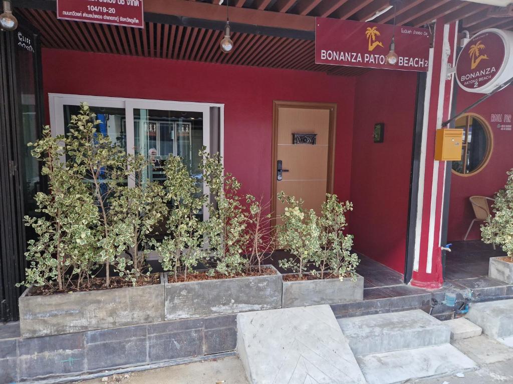 een rood gebouw met planten ervoor bij Bonanza Patong Beach2 100m to Beach Green Room in Patong Beach