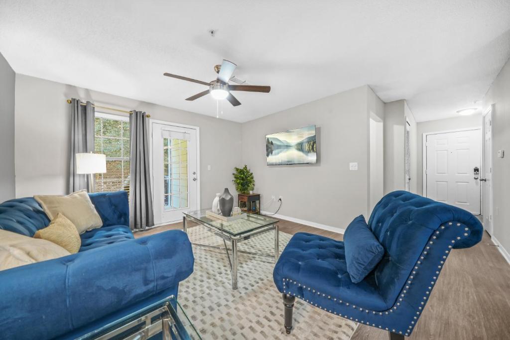 un soggiorno con un divano blu e un tavolo di Lux 3BR, Prime Location Near UGA & Downtown Athens ad Athens