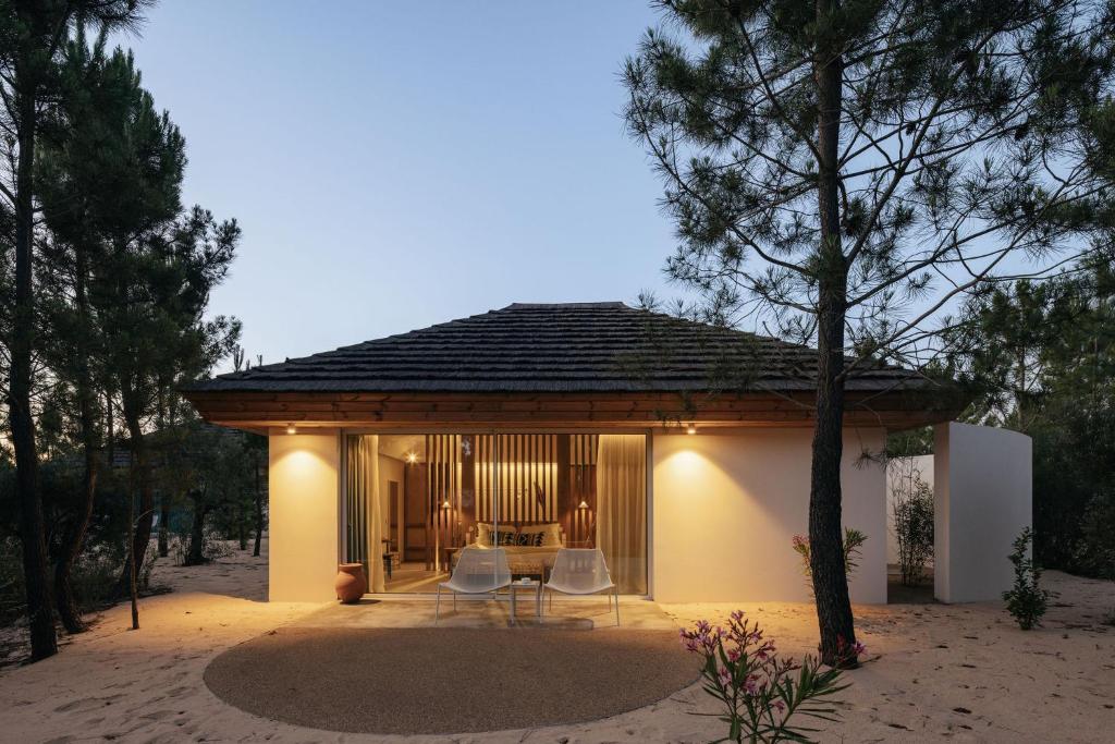 a small house with a table and chairs in the sand at Spatia Comporta in Comporta