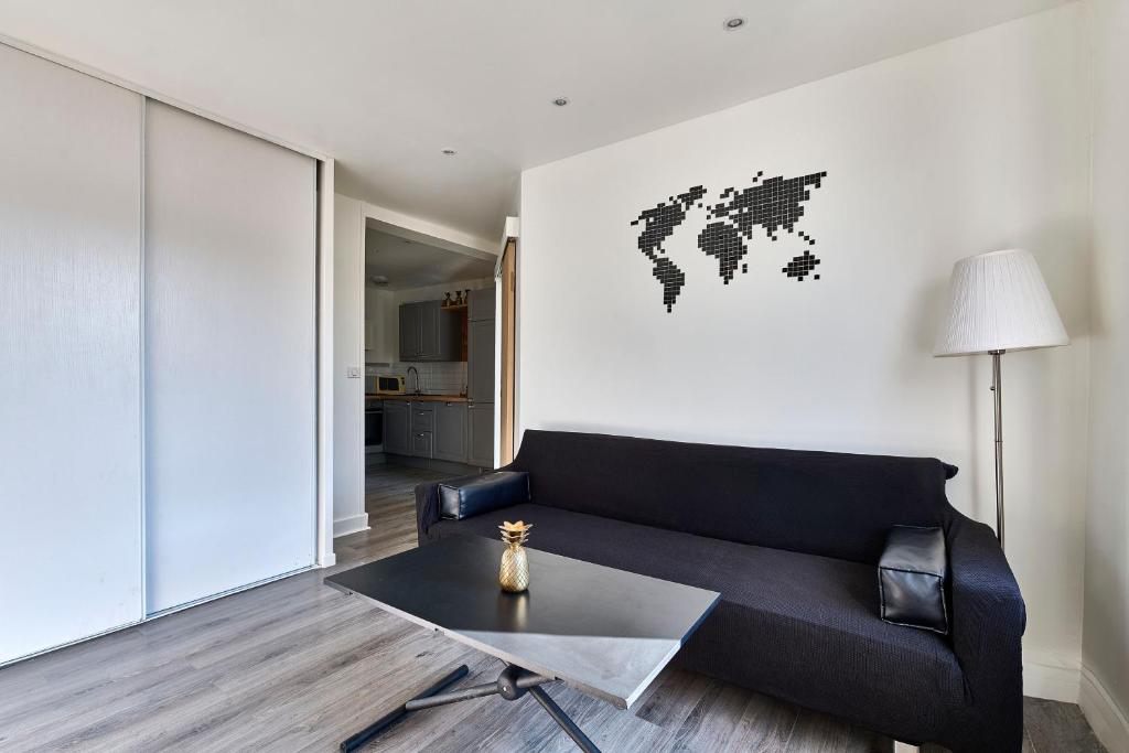 un salon avec un canapé noir et une table dans l'établissement Louvre Museum 35 mins away, à Saint-Maurice