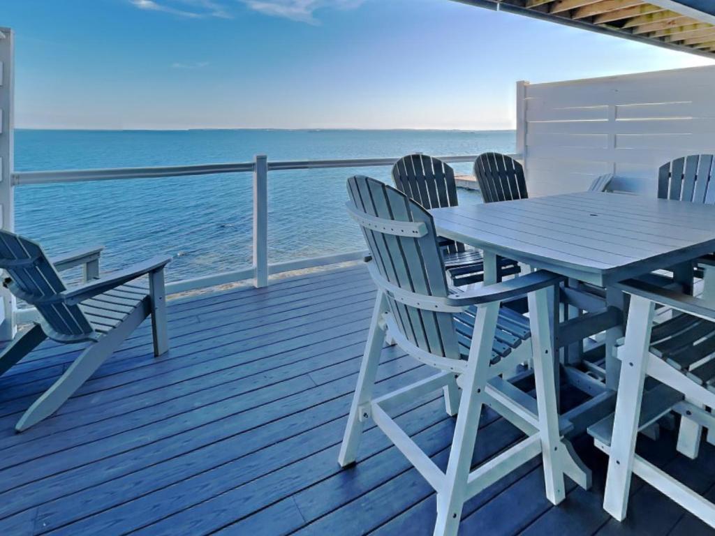 a wooden deck with a table and chairs on the beach at Put-in-Bay Waterfront Condo #111 in Put-in-Bay