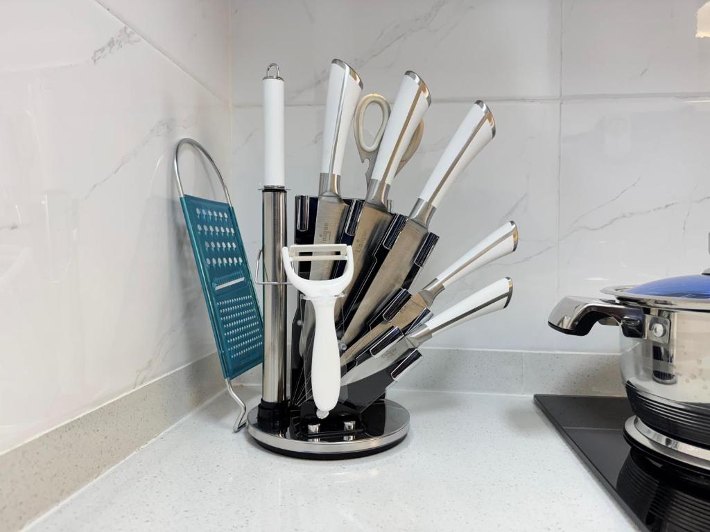 内罗毕Sunset Cosy abode的柜台上的容器里的厨房用具