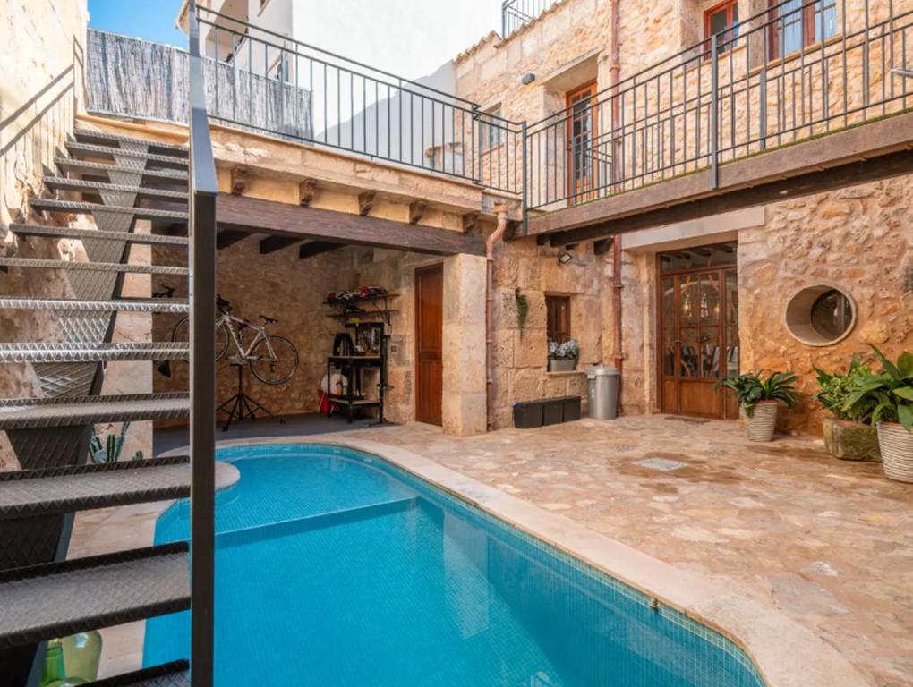a house with a swimming pool and a staircase at Cas Mercader in Algaida