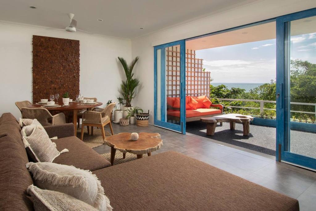a living room with a couch and a table at Hossegor - Tropical 1 Bedroom Ocean View Apartment by Triang Villas in Tanah Lot
