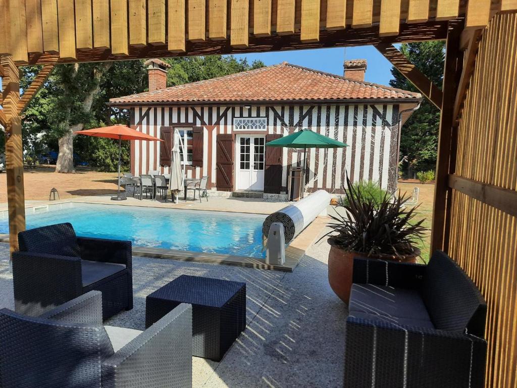 a patio with a swimming pool and a house at Cante alaoude in Linxe