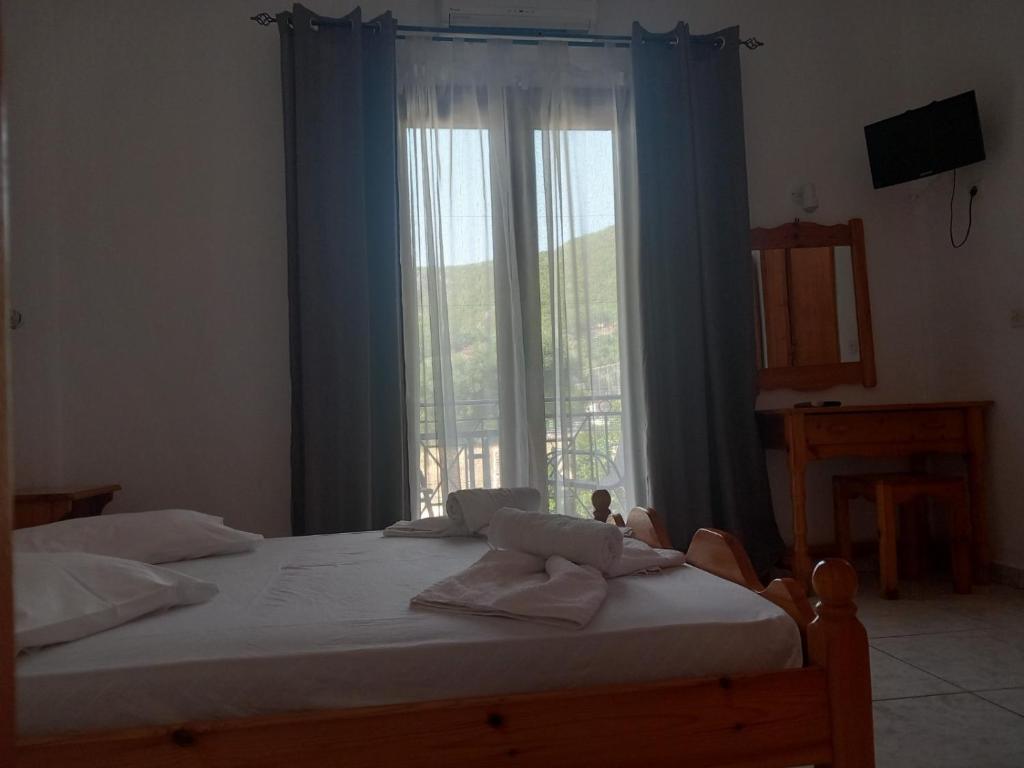 a bedroom with a bed with a large window at Εξοχή in Parga