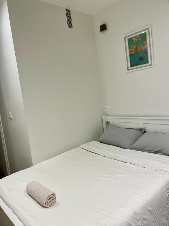 - un lit blanc avec une serviette dans l'établissement Private Studio 15m2 a Porte Maillot, à Paris